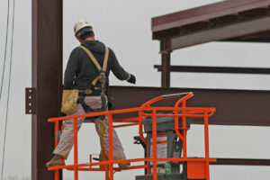 Steel worker bolting together steel beams for new building